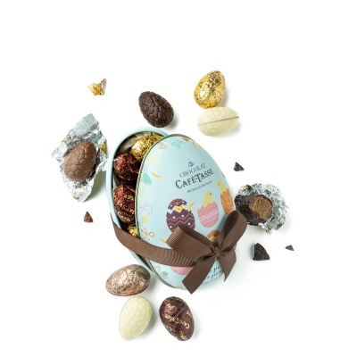 Caixa ovo azul claro com laço castanho e ovos de chocolate variados em volta