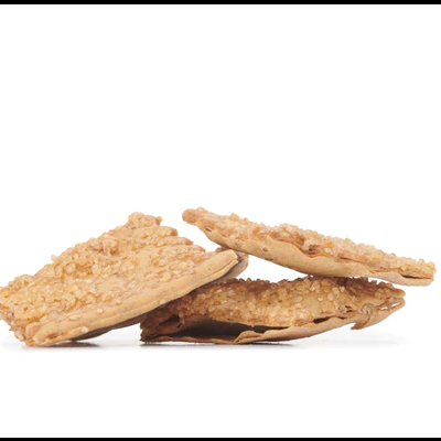 Três bolachas crocantes com sementes de sésamo num fundo branco