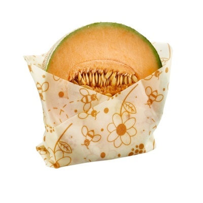 Melão cortado embalado em papel com padrão de flores e abelhas