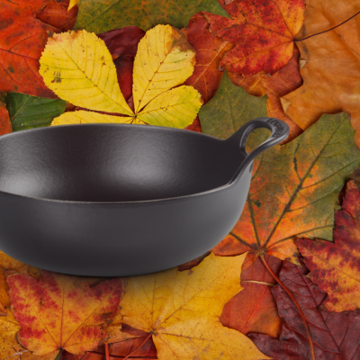 Panela de ferro fundido preta com alças sobre folhas de outono coloridas