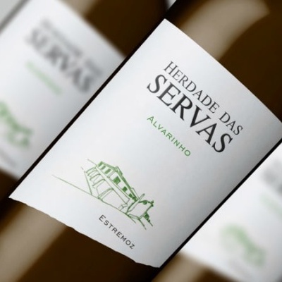 Garrafas de vinho branco Herdade das Servas Alvarinho com rótulo branco e desenho verde