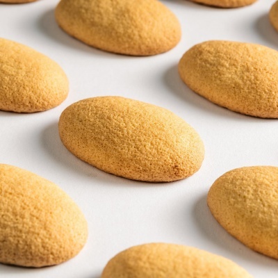 Bolos ovais dourados com textura esponjosa sobre fundo branco.