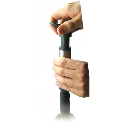 Mãos a manusear dispositivo cilíndrico preto e metalizado em fundo branco