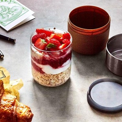 recipiente vidro com aveia, iogurte e morangos, croissant e copo térmico com tampa