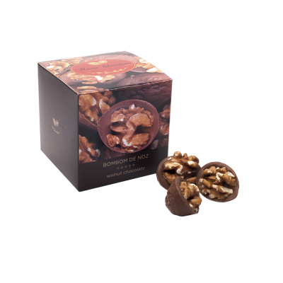 Caixa com bombons de noz em chocolate castanho e embalagem com texto 'BOMBOM DE NOZ walnut chocolate'