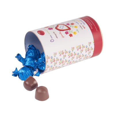 Cilindro branco com doces embrulhados azuis e dois chocolates ao lado