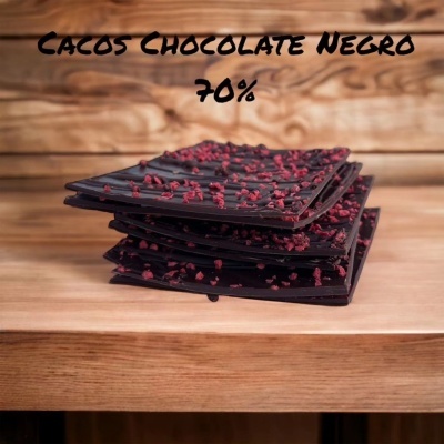 Barras de chocolate negro com pedaços vermelhos empilhadas em madeira, texto acima.