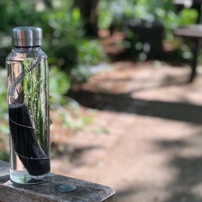 Garrafa de vidro com tampa metálica em ambiente exterior