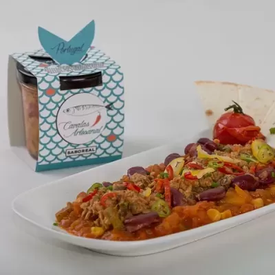 Frasco de compota artesanal com rótulo e prato com guisado variado e tortilha