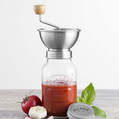 Frasco Kilner com máquina de moer e ingredientes em bancada de madeira.