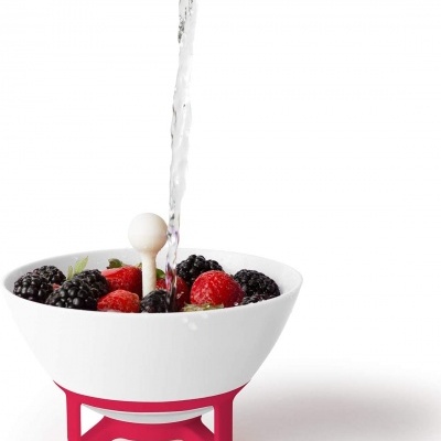 Tigela branca com frutas vermelhas e fluxo de água