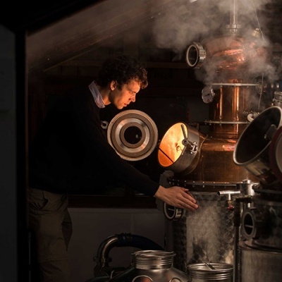 Homem a operar equipamento industrial de cobre com vapor num ambiente escuro
