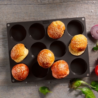 Forma de silicone preta com pequenos pães com sementes de sésamo