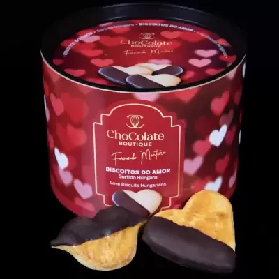 Embalagem vermelha de biscoitos em forma de coração com coberturas de chocolate escuro.