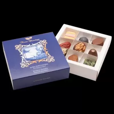 Caixa de chocolates sortidos azul com tampa aberta a mostrar chocolates variados em tabuleiro branco