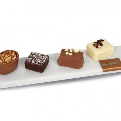 Quatro chocolates variados em placa branca com placa identificativa GO SOLA