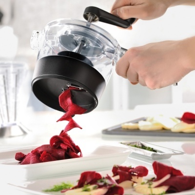 Ralador manual a ralar beterraba em cozinha moderna branca