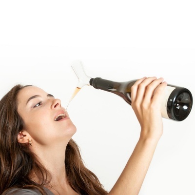 Mulher a beber de garrafa escura com rótulo branco