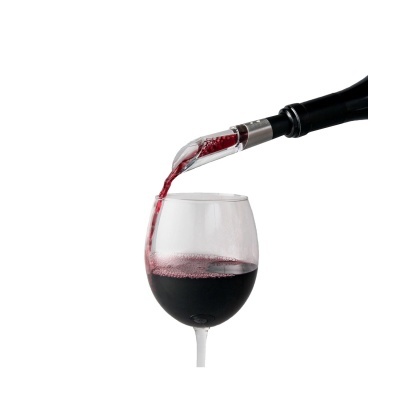 Vinho tinto a ser servido numa taça de vidro por uma garrafa com bico metálico.