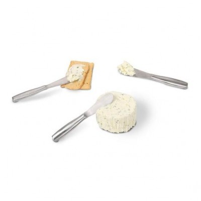 Queijo cremoso branco com ervas, espátulas metálicas e bolacha