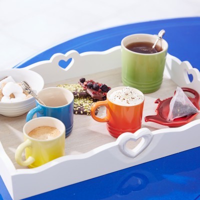 Bandeja branca com chávenas coloridas, açúcar e chocolate