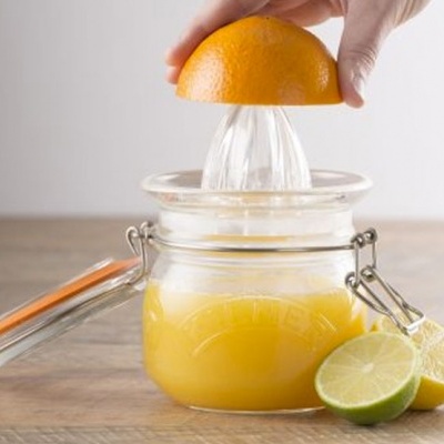 Espremer sumo manual em vidro com laranja e limão sobre mesa de madeira