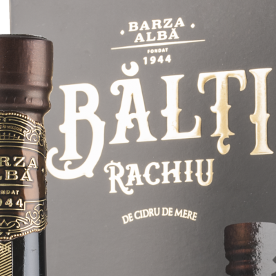 Garrafa preta com texto dourado de bebida alcoólica e embalagem preta correspondente