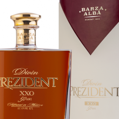 Garrafa de Divin Prezident XXO 50 Anos com embalagem à direita, texto dourado e fundo claro