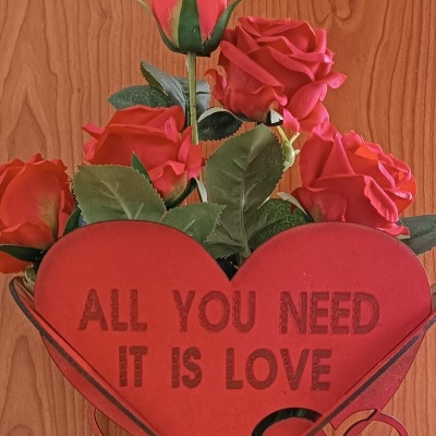 Arranjo decorativo com rosas vermelhas artificiais em vaso coração vermelho com texto