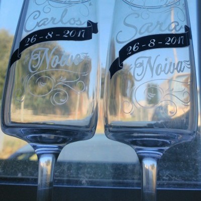 Dois copos de champanhe gravados com nomes e data de casamento.
