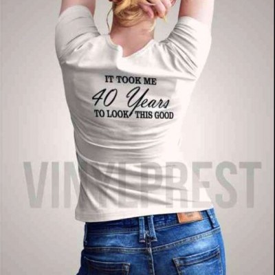 Mulher de costas com t-shirt branca escrita e jeans azuis