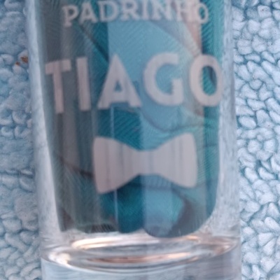 Copo de vidro gravado com texto 'PADRINHO TIAGO' e desenho de gravata borboleta