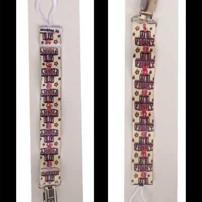 Dois porta-chupetas com tecido branco com desenhos de presentes e texto HAPPY