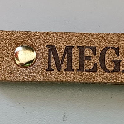 Chaveiro castanho claro com texto MEGANE a preto e argola metálica dourada