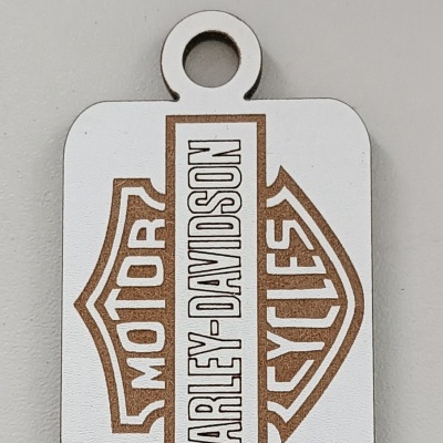 Pingente metálico com gravação Harley-Davidson.