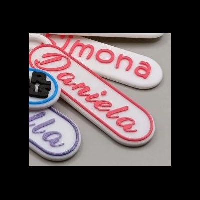 Marcadores de nomes em borracha colorida sobre superfície cinza claro