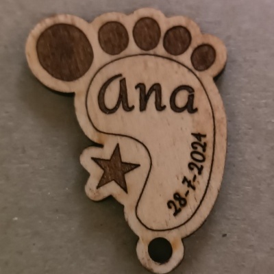 Pendente de madeira em forma de pé com gravuras e texto