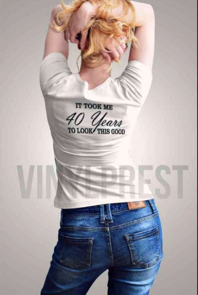 Mulher de costas com t-shirt branca escrita e jeans azuis