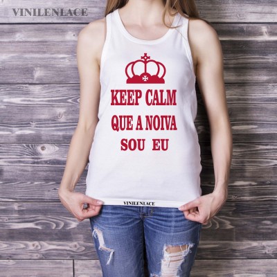 Camisola branca sem mangas com texto vermelho e coroa, usada por mulher com calças de ganga rasgadas