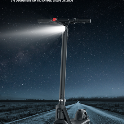 Patinete elétrico preto com farol LED ligado numa estrada à noite