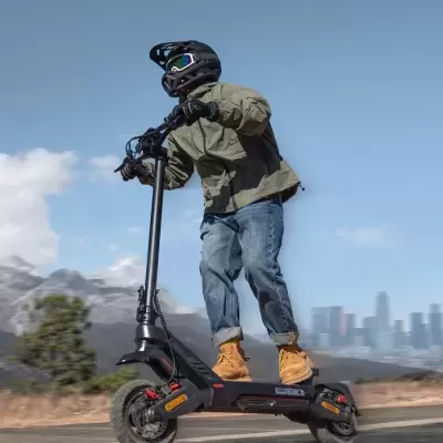 Patinete elétrico preto com pessoa com capacete, casaco verde e botas castanhas a andar na estrada