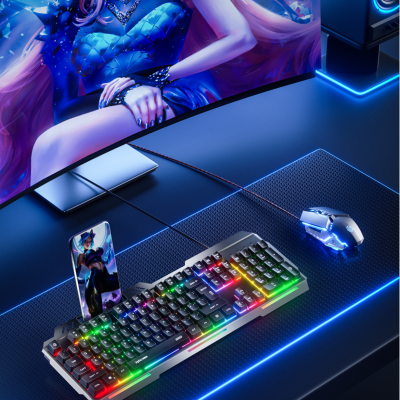 Setup gaming com teclado mecânico RGB, rato iluminado e monitor curvo exibindo personagem feminino.