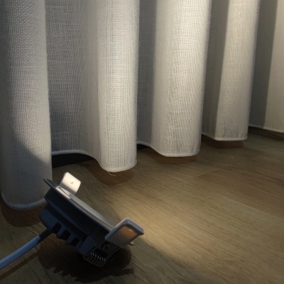 Luz LED embutida com suporte metálico sobre chão de madeira clara