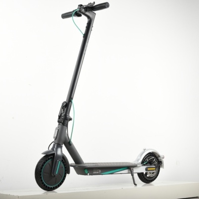 Trotinete elétrica cinzenta e preta com detalhes verdes em plataforma branca