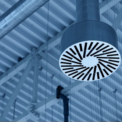 Difusor de ventilação circular de cor preta e branca fixado ao teto metálico.