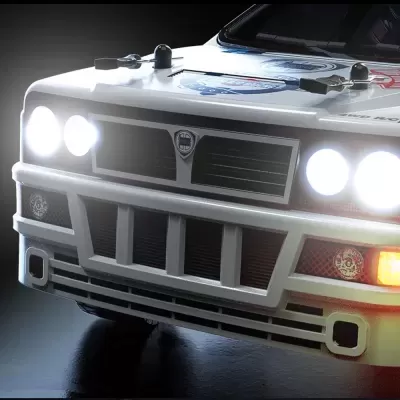 Frontal de carro clássico branco com faróis acesos e autocolantes no capô