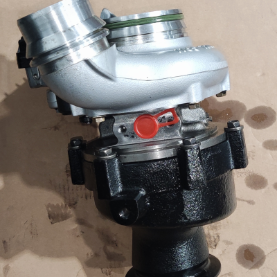 Turbo metálico com carcaça prateada e base preta sobre fundo castanho