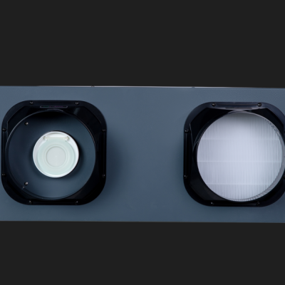 Filtro ou componente de ventilação metálico com duas aberturas quadradas e elementos circulares e em grelha