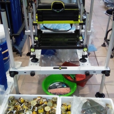 Cadeira de pesca preta e amarela com suporte metálico branco em loja de pesca