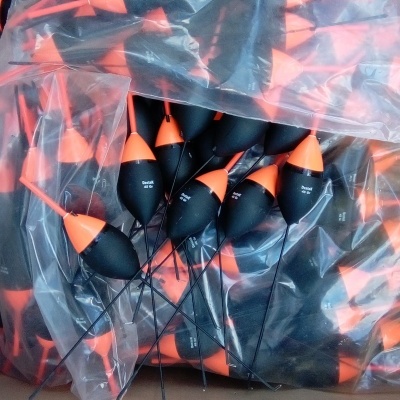 Boias de pesca pretas e laranja numa caixa de cartão